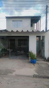 una casa bianca con una recinzione di fronte di Simples e Aconchegante a Mogi das Cruzes