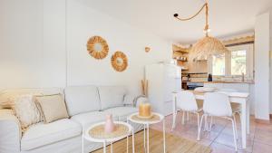a living room with a white couch and a kitchen at Palm Beach House in Corralejo