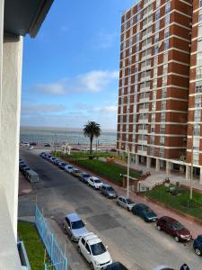 un parking avec des voitures garées à côté d'un grand bâtiment dans l'établissement Apartamento en Barrio Sur DOS HABITACIONES, à Montevideo