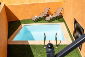 two chairs and a swimming pool in a building at Palm Beach House in Corralejo