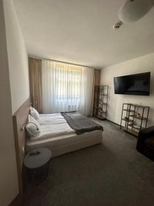 a bedroom with a bed with a window and a tv at Апартхотел Флора 213Б in Borovets