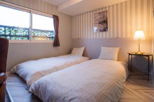 a bedroom with a bed and a window at InnCocoSumu？ - Vacation STAY 09335v in Kirishima