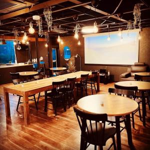 a room with tables and chairs and a projection screen at InnCocoSumu？ - Vacation STAY 03969v in Kirishima