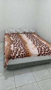 a bed with a cheetah blanket on the floor at Hotel Gods Time Is The Best in Boa Vista