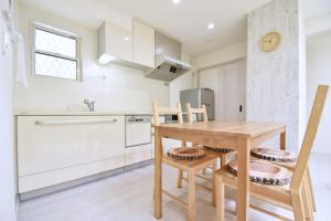 cocina con mesa de madera y sillas en Magical Dream House ★ Maihama - Vacation STAY 12402 en Tokio