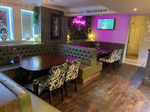 a restaurant with a table and chairs and purple walls at The Ivy Tree in Stockton-on-Tees