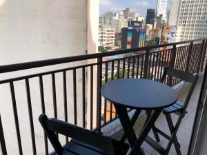a table and chairs on a balcony with a view of a city at SeuLar o conforto de um Lar em Qualquer Lugar in Sao Paulo