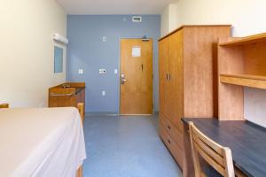 1 dormitorio con 1 cama y armario de madera en Dalhousie University, en Halifax