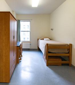 Habitación pequeña con cama y ventana en Dalhousie University, en Halifax