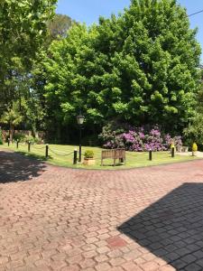 a park with a bench and flowers and trees at Tanglewood Gatwick Bed & Breakfast in Crawley