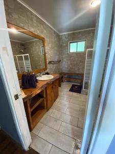 un baño con lavabo y espejo en Lodge Dream Pucon, en Pucón