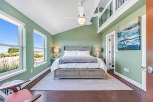 a bedroom with green walls and a bed with a ceiling fan at Dream Weaver House with Hot Tub and Ocean View! in Manchester