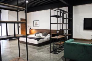 a bedroom with a bed and a room with a ladder at Loft platino en excelente ubicación! in San Luis Potosí
