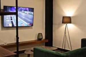 a living room with a tv and a green couch at Loft platino en excelente ubicación! in San Luis Potosí