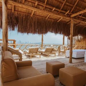 a living room with chairs and a straw roof at Estadía en hermoso hotel en la isla de punta arena cartagena in Playa Punta Arena
