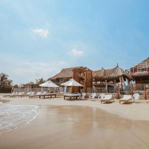 - une plage avec des chaises et des parasols dans l'établissement Estadía en hermoso hotel en la isla de punta arena cartagena, à Playa Punta Arena