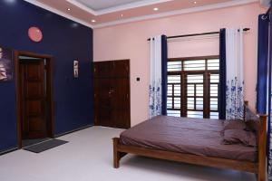 een slaapkamer met een bed met blauwe muren en een raam bij Hajiz Palace in Jaffna