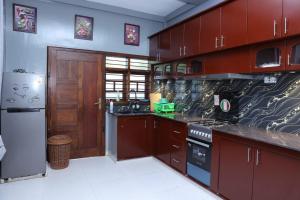 een keuken met houten kasten en een fornuis met oven bij Hajiz Palace in Jaffna