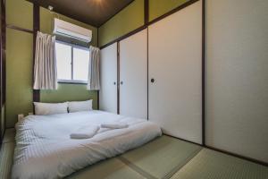 Rúm í herbergi á Shiki Homes | KURIKO - Vacation STAY 12788