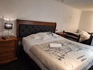 a bedroom with a bed with a black and white comforter at Hotel Terrasol Iquique in Iquique