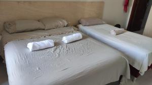 two beds sitting next to each other in a bedroom at kitnet Águas Claras in Águas Claras