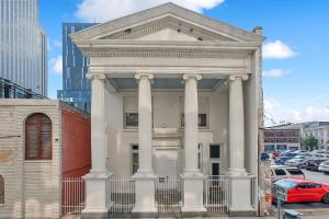 a white building with columns in a city at Spacious Downtown New Orleans Vacation Rental in New Orleans