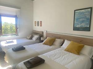 a room with three beds and a window at Sereno rincón de montaña in Sant Corneli de Cercs 