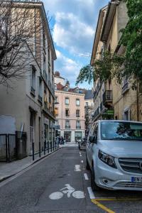 une camionnette blanche garée sur le côté d'une rue dans l'établissement Coeur centre ville Grenoble - charme de l'ancien, à Grenoble