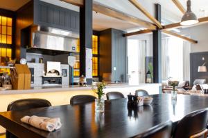 a dining room with a table and a kitchen at Canopy By Hilton Ithaca Downtown in Ithaca