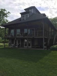 a large house sitting on top of a lush green field at Waterfront Home on Bantam Lake with Private Beach in Morris