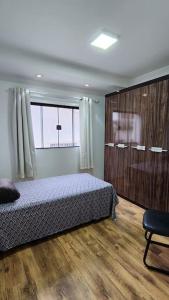 a bedroom with a bed and a large window at Casa Única e Moderna Centro in Poços de Caldas