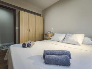 1 dormitorio con 1 cama blanca grande y toallas. en Pilar 19 - Piso céntrico en el Pilar, en Talavera de la Reina