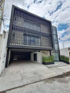 a building with a parking lot with a garage at Loft níquel en excelente ubicación! in San Luis Potosí
