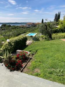 un jardín con flores rojas y una piscina en Agriturismo Nonna Bettina, en Moniga del Garda