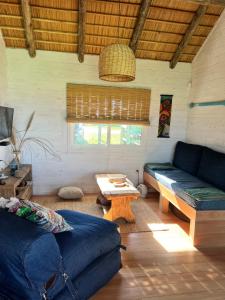 een woonkamer met een bank en een tafel bij Palapa Suite in Punta Del Diablo