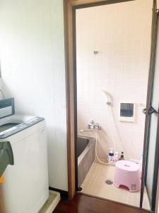 ein Badezimmer mit einer Badewanne und einem rosa WC auf dem Boden in der Unterkunft HolidayCottage”BANSHIRO” - Vacation STAY 10623v in Setouchi