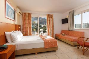 um quarto de hotel com uma cama e um sofá em Agrabella Hotel em Hersonissos
