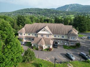 una vista aérea de una casa grande con aparcamiento en LeChamplain #206 CITQ#248275 en Bromont