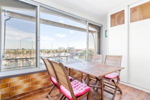 a dining room with a table and chairs and a large window at Apartamento WELCS EMP-096- con vistas al canal in Empuriabrava