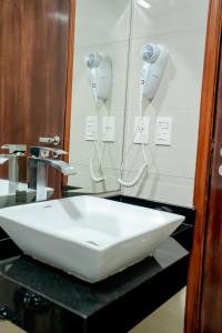 Megal Suites Hotel في سيوداد ديل إستي: بالوعة بيضاء على كونتر في الحمام