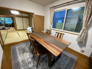 comedor con mesa de madera y sillas en [Luxury villa with BBQ facilities overlooking Moun - Vacation STAY 14273, en Oishi
