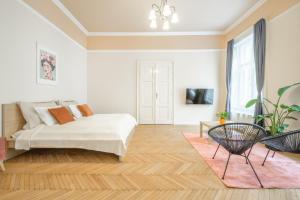 Dormitorio blanco con cama y mesa en Best Seasons Andrássy, en Budapest
