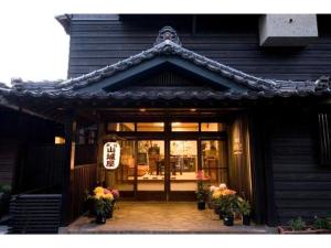 a store front of a building with flowers in front of it at Ryokan Yamashiroya - Vacation STAY 21527v in Yufu