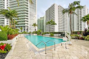 a swimming pool with palm trees and buildings at Beautiful 1 Bedroom Brickell in Miami