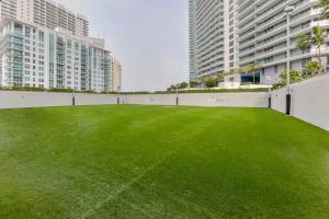 a large green field in the middle of two buildings at Beautiful 1 Bedroom Brickell in Miami
