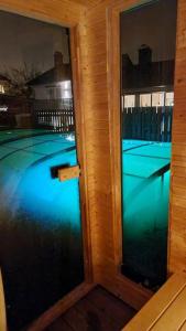 uma vista para uma piscina através de duas portas de vidro em Central villa med extra allt. Pool, Bastu, Utekök em Kalmar