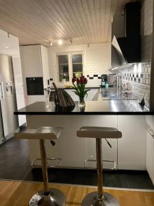 a kitchen with a counter and two bar stools at Central villa med extra allt. Pool, Bastu, Utekök in Kalmar