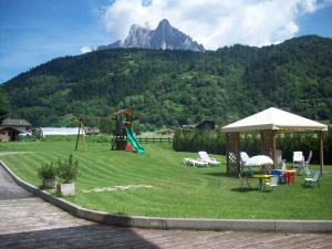 a park with a playground with a mountain in the background at Hotel Al Prato in Fiera di Primiero