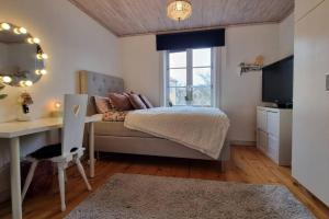 een slaapkamer met een bed, een bureau en een raam bij Central villa med extra allt. Pool, Bastu, Utekök in Kalmar