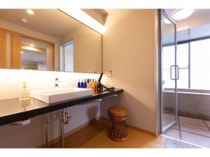 y baño con lavabo y espejo. en 〜Ｇｒａｎｄｐｉａ Ｒｅｓｏｒｔ ＯＵＧＩＹＡＭＡ〜 - Vacation STAY 50995v en Beppu